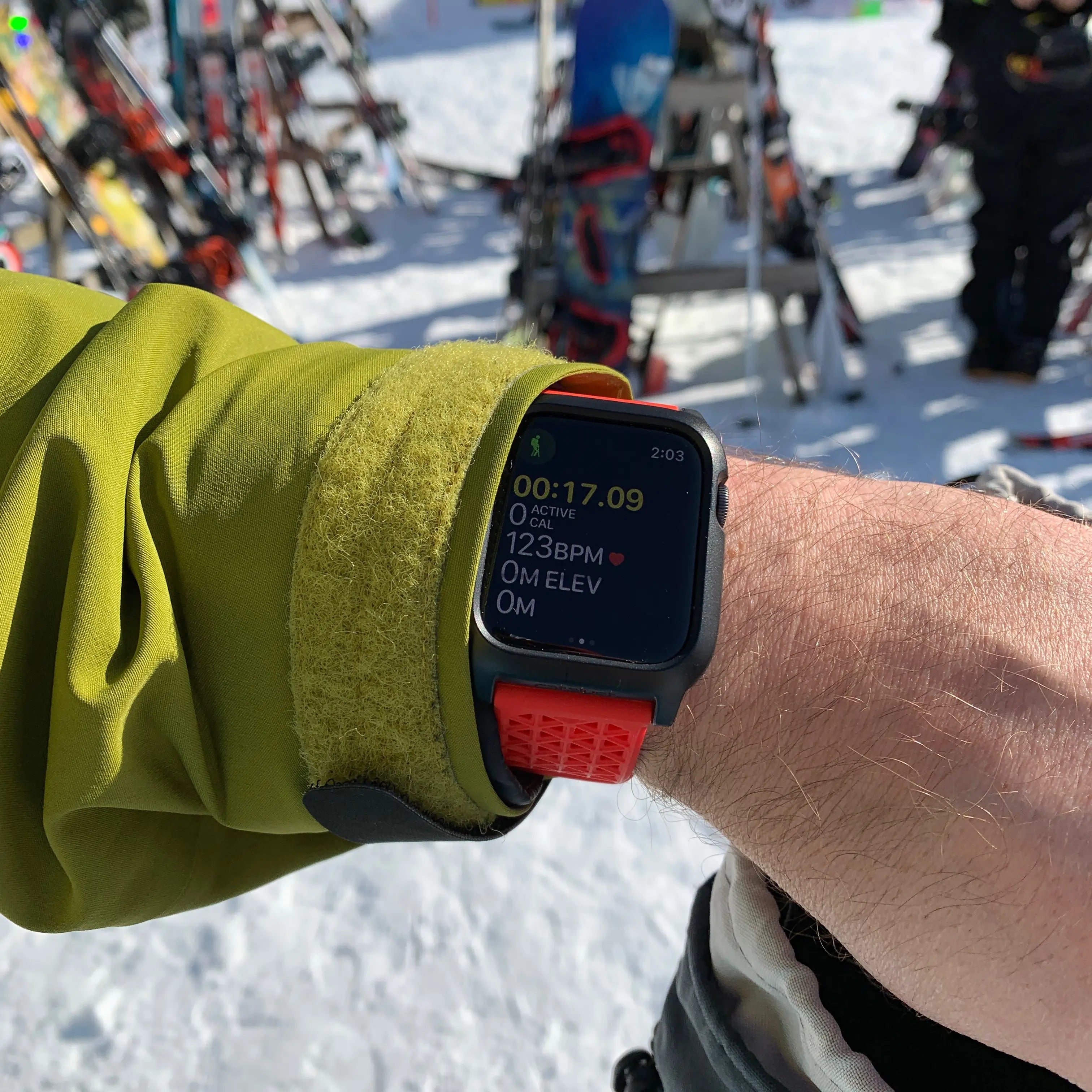 Someone wears an Apple Watch with a black Catalyst waterproof case, showing activity time and a heart rate of 123 BPM at 0M elevation. The snowy backdrop and ski gear emphasize its drop-proof design, ideal for the adventurous spirit.