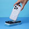 A hand holding an iPhone with a Catalyst Drop Proof Case over a stack of iPhones against a blue background.